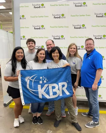 KBR employees with the KBR flag at the Houston Food Bank