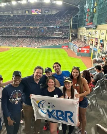KBR employees with the KBR flag at a Houston Astros game